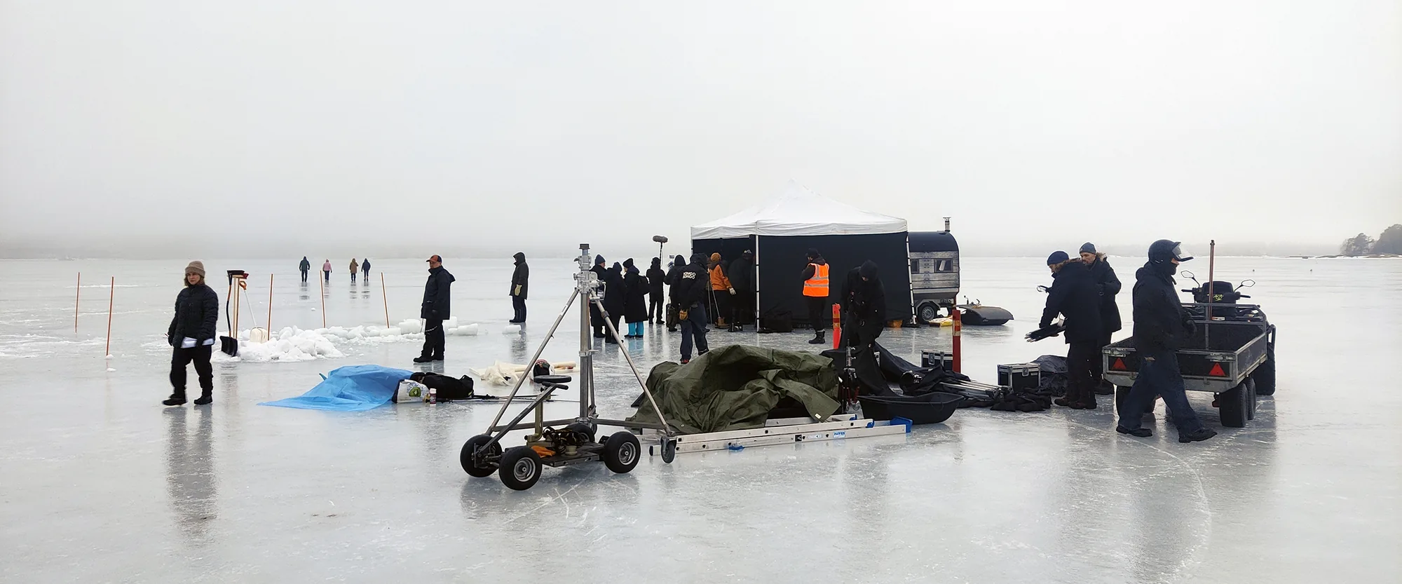 Film crew and equipment working on a frozen lake